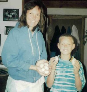 Mary Ann with son, Joshua, holding eggs from chickens