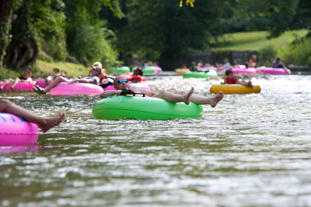 people floating down a river in inner tubes