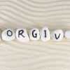 Forgive word on group of stones on the sand