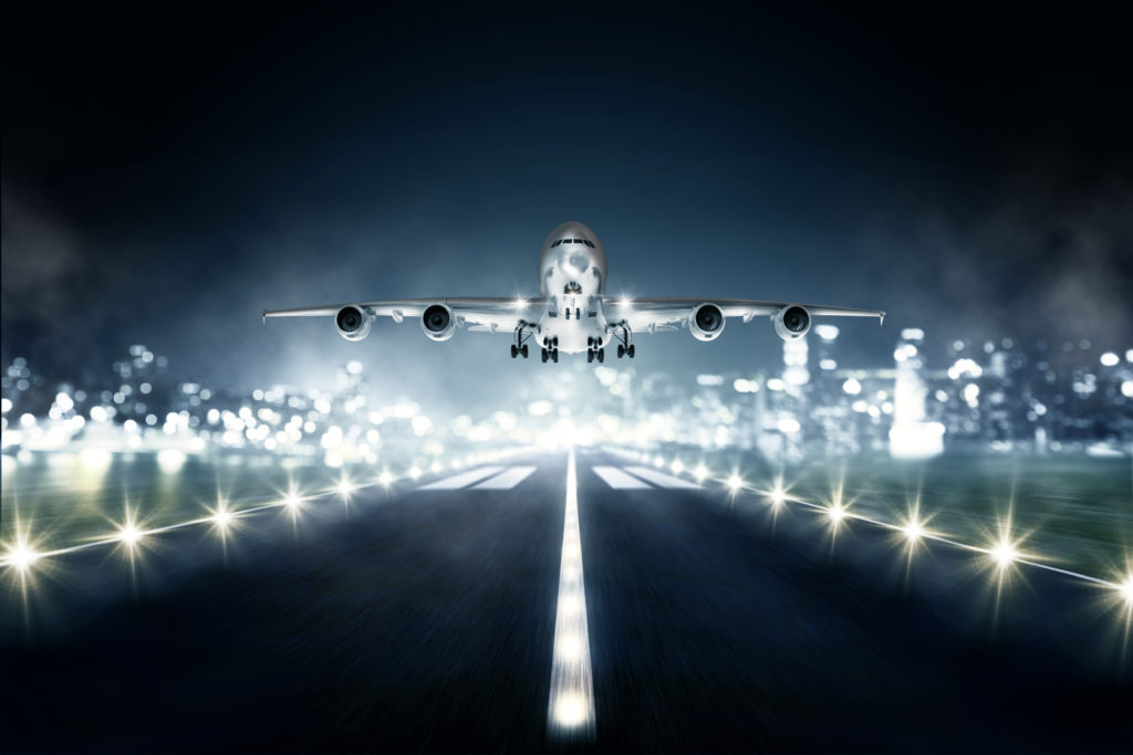 airplane landing at night on lighted runway